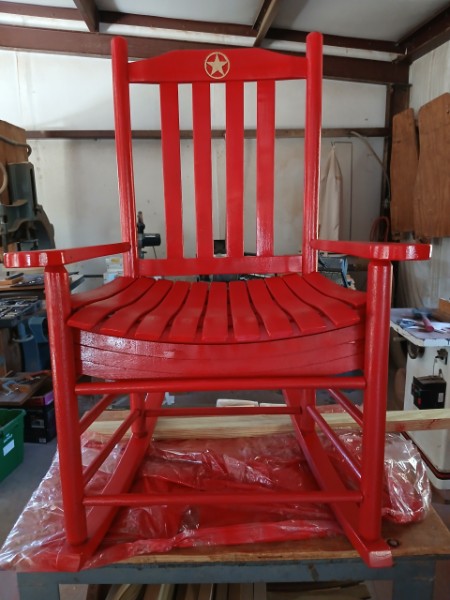 Handcrafted red porch rocker in the woodshop